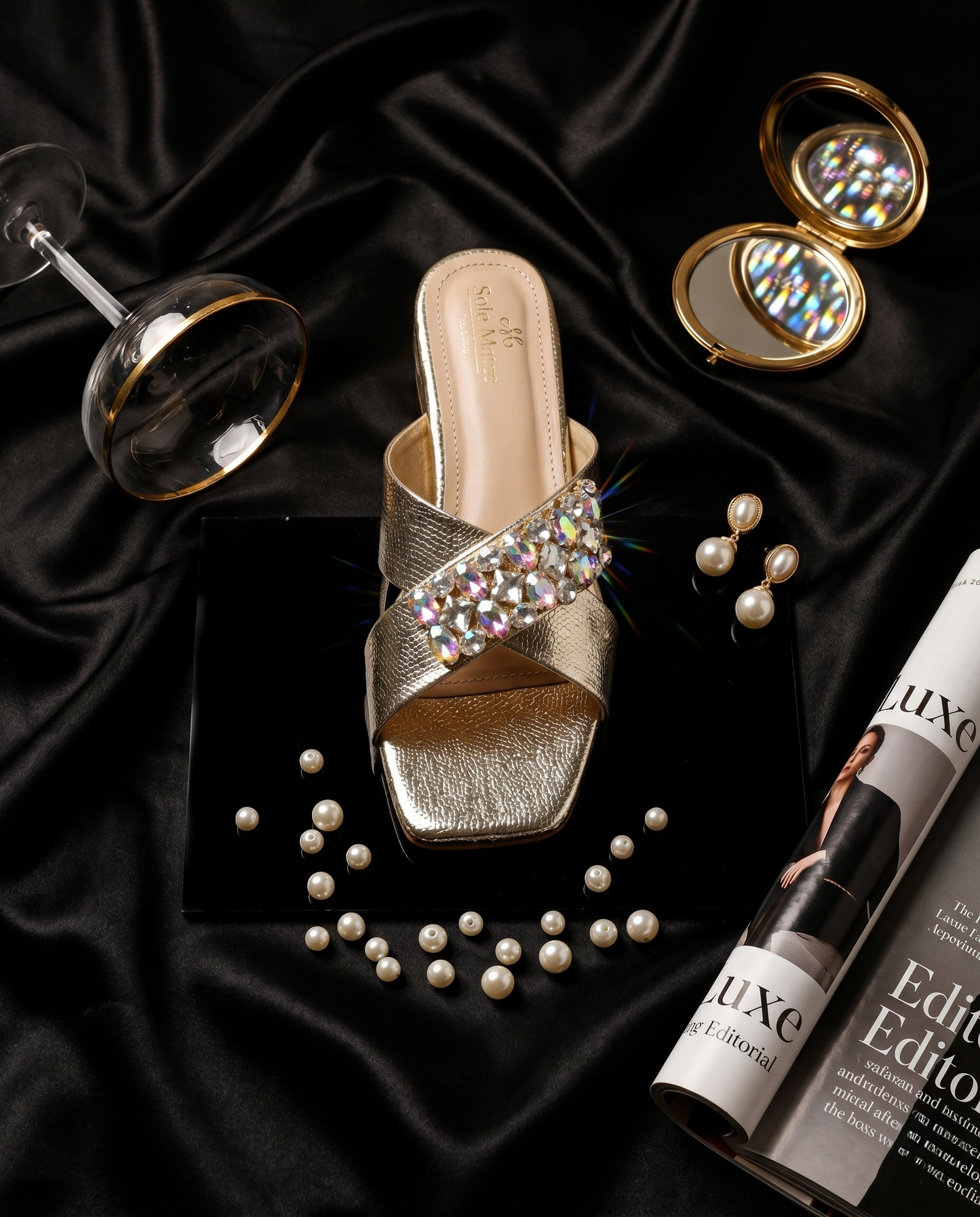 Charolette Gold Sliders flat lay on black satin with pearls, compact mirror and magazine — champagne gold criss-cross metallic sliders with AB crystal cluster by Solemates by Palak